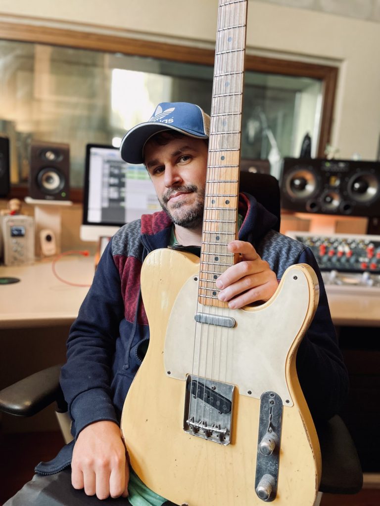 Coqui en un estudio de grabación sujetando una guitarra Telecaster